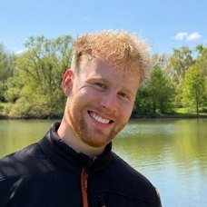 Jan Philip Wahle, smiling, standing at a lake